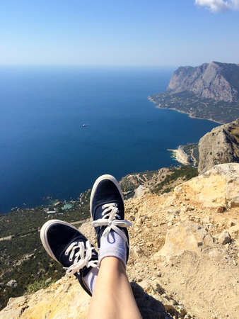 Legs in sneakers, of a man sitting on the topの写真素材