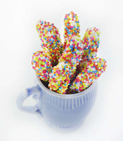 biscuit stick coated with rainbow in blue cupの写真素材