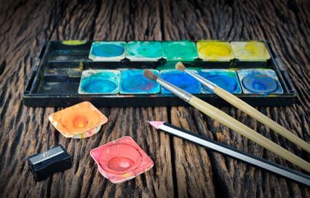 Closeup of messy, used water color paint box and paint brushの写真素材