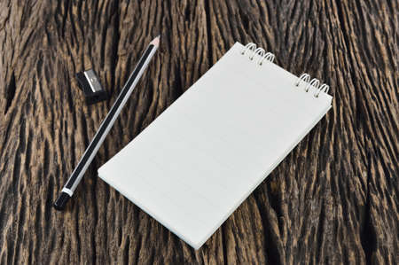 Blank Note Book With Wood Pencil on Wooden Table Desk Backgroundの写真素材