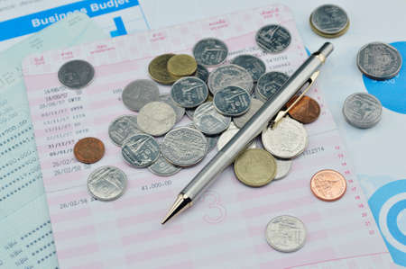 Pen and coin on saving book, accounting backgroundの写真素材
