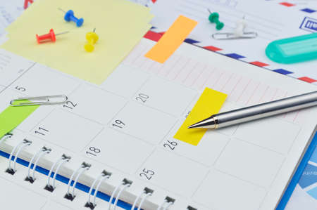 Pencil with colorful post It notes and pin on business diary pageの写真素材