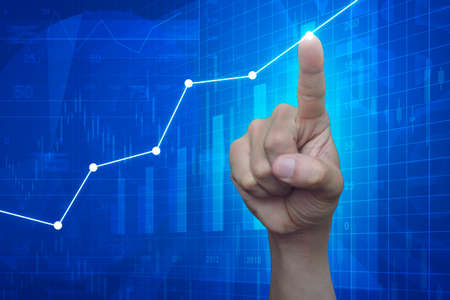 Hand point to graph on financial and business chart and graphs, success conceptの写真素材