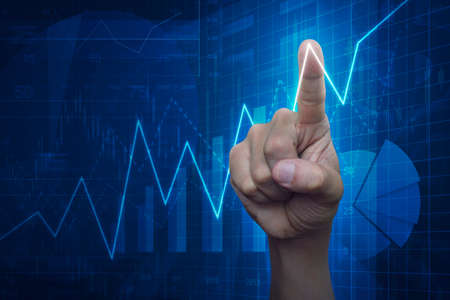 Hand point to graph on financial and business chart and graphs, success concept
