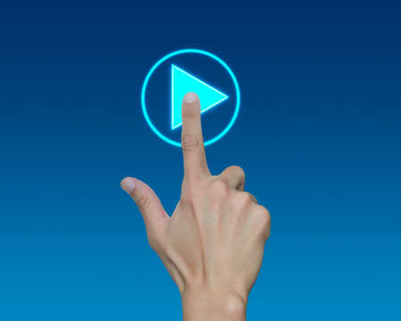 Man hand push start button on touch screen over blue backgroundの写真素材