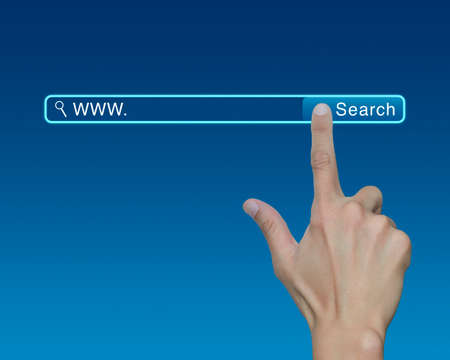 Hand pressing search button over blue background, searching system and internet conceptの写真素材