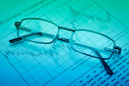 Glasses on stock market graph, financial and business conceptの写真素材