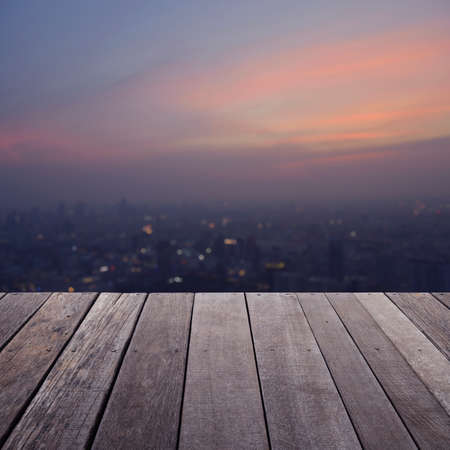 Empty old wood floor with blurred aerial view of cityscape on warm light sundown, for your product display montageの写真素材