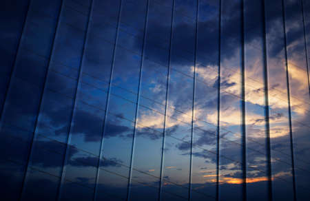 Reflection of sunset sky in metal wall of office building