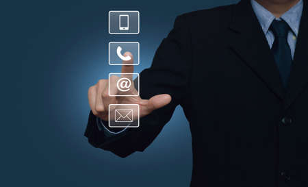 Businessman pressing telephone, mobile phone, at and email buttons over blue background, Customer...