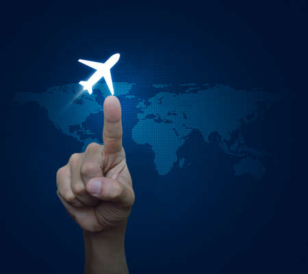 Hand pressing airplane button over digital world map blue background, Airplane transportation conceptの写真素材