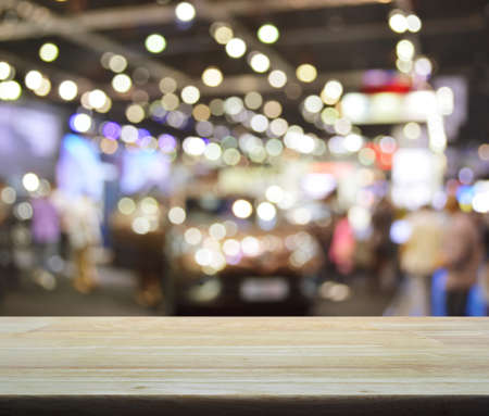 Empty wooden table over defocused light and shadow of shopping mall, for product display