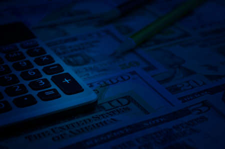 Calculator and pencil on dollar bank note money, Finance concept, blue toneの写真素材