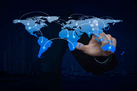 Businessman hand pushing global world business connection map over city tower.の写真素材
