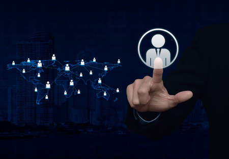 Businessman hand click businessman icon with light blue world map connection on city towerの写真素材
