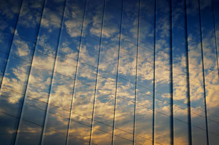 Reflection of sunset sky in metal wall of office buildingの写真素材