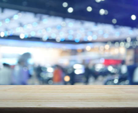 Empty wooden table over defocused light and shadow of shopping mall, for product display