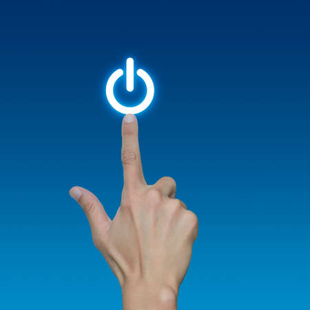 Hand pressing power button on blue background, Start up concept