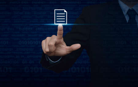 Businessman pressing document icon over computer binary code blue backgroundの写真素材