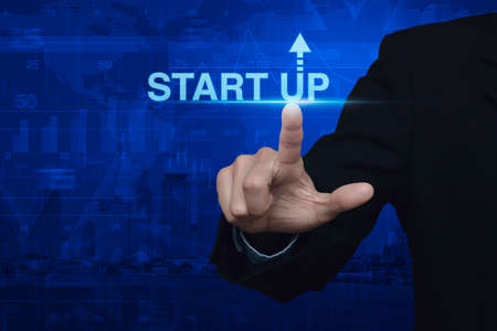 Businessman pressing start up icon over map and city background, Start up business conceptの写真素材