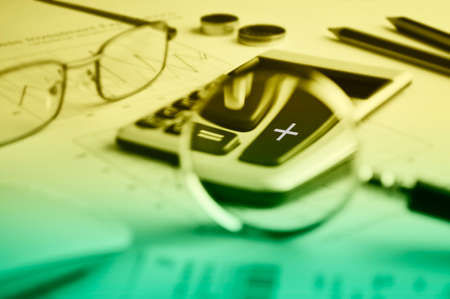Calculator button plus and magnifying glass on graph paper background, Success business conceptの写真素材