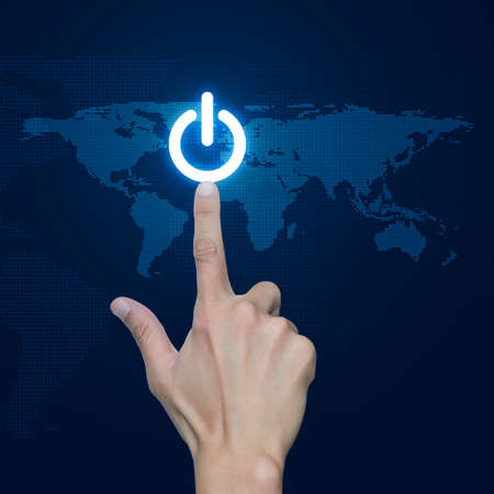 Hand pressing power button over digital world map blue background