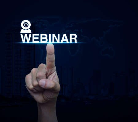 Hand pressing webinar button over world map and city tower, Seminar online conceptの写真素材