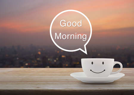 Happy smile white coffee cup on wooden table over blur cityscape on warm light sunshine, Good...