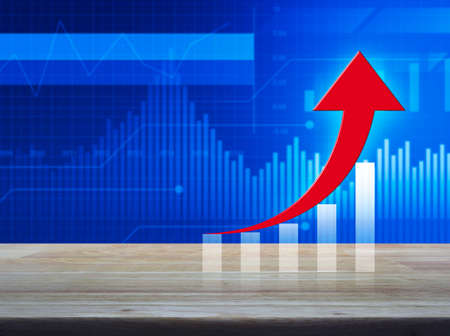 Red arrow with graph on wooden table over financial graph and chart, Success business conceptの写真素材