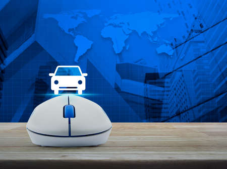 Wireless computer mouse with car front view flat icon on wooden table over world map and city tower background, Internet service car concept, Elements of this image furnished by NASAの写真素材