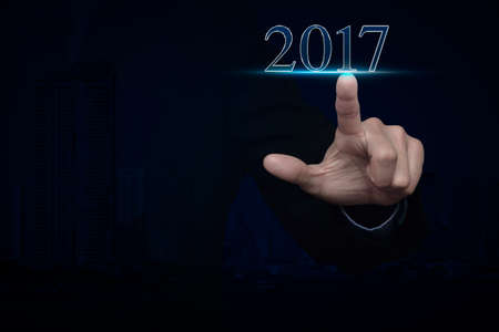 Businessman pressing 2017 text over modern city tower background, Happy new year conceptの写真素材