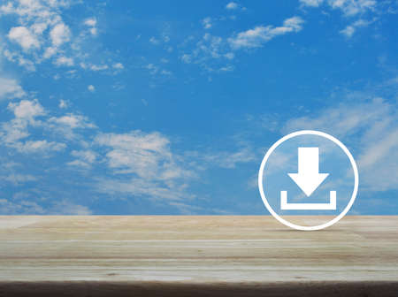 Download icon on wooden table over blue sky with white clouds, Business internet conceptの写真素材