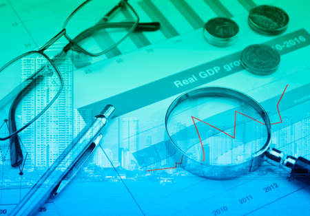 Magnifying glass with growth graph over modern city tower, Business success concept