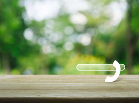 Phone icon with copy space for add your phone number on wooden table over blur green tree...