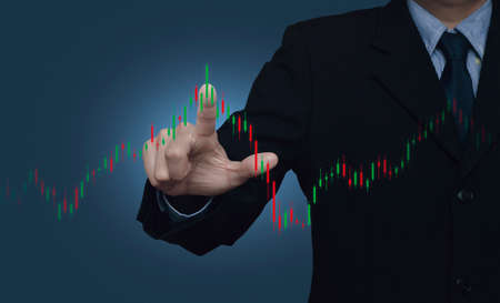 Businessman pressing to trading graph of stock market over gradient light blue background, Business...