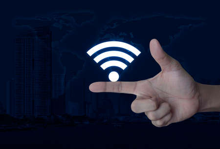 Wifi icon on finger over world map and modern city tower, Technology and internet conceptの写真素材
