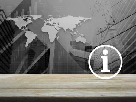 Information sign icon on wooden table over world map with financial graph and city tower, Business communication concept, Elements of this image furnished by NASAの写真素材