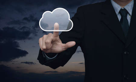 Businessman pressing cloud button over sunset sky, Internet conceptの写真素材