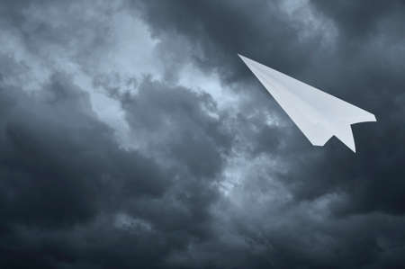 Plane paper flying dark storm clouds sky before rain, Business leader conceptの写真素材