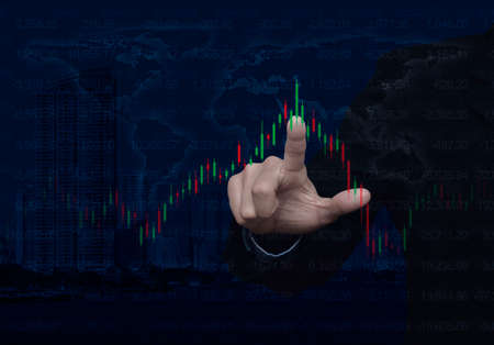 Businessman pressing to trading graph of stock market over world map and modern city tower, Business investment concept, Elements of this image furnished by NASAの写真素材
