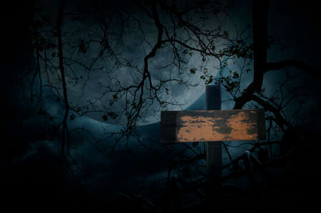 Cross over old fence, dead tree, moon and cloudy sky, Spooky background, Halloween conceptの写真素材