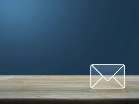 Mail icon on wooden table over light gradient blue background, Contact us conceptの写真素材