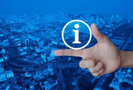 Information sign icon on finger over modern city tower, street and expressway, Business communication conceptの写真素材