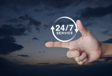 24 hours service icon on finger over sunset sky, Full time service conceptの写真素材