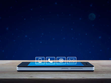Telephone, mobile phone, at and email buttons on modern smart phone screen on wooden table over...