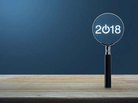 2018 start up icon with magnifying glass on wooden table over light blue gradient background,...