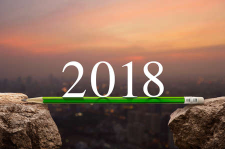 2018 white text with green pencil on rock over blur of cityscape on warm light sundown, Business success strategy plan concept, Happy new year 2018 calendar coverの写真素材