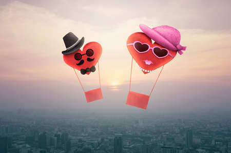 Heart red love ballon character man and woman over aerial view of cityscape at sunset, vintage style, Valentines day conceptの写真素材