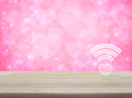 Heart wifi icon on wooden table over blur pink background, Internet online love connection, Valentines day conceptの写真素材