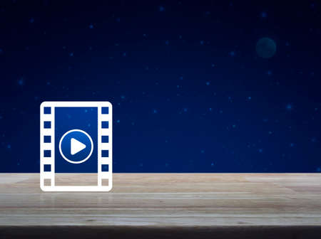 Play button with movie icon on wooden table over fantasy night sky and moon, Cinema online concept